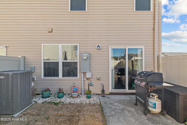 rear view of property featuring central air condition unit and fence