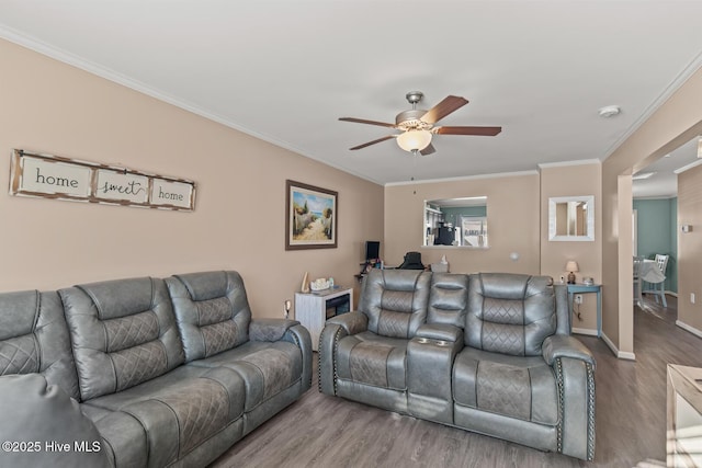 living room with baseboards, wood finished floors, ceiling fan, and crown molding