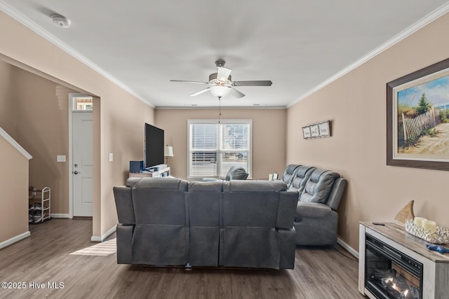 living room featuring wood-type flooring, ornamental molding, and ceiling fan