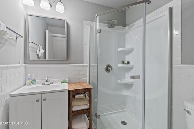 bathroom featuring vanity, a shower with shower door, and tile walls