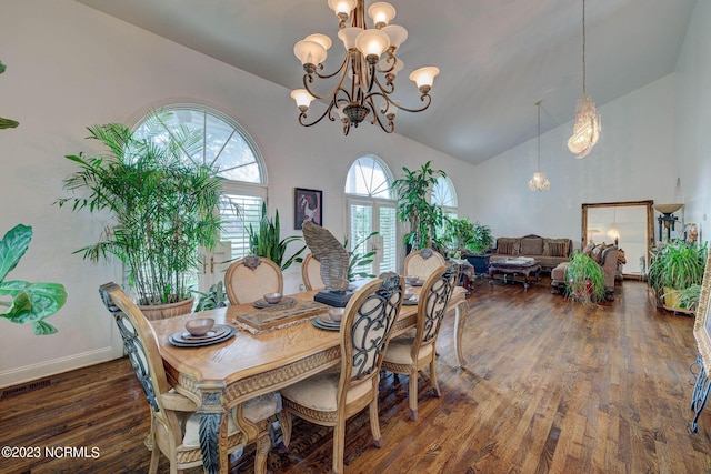 dining area featuring dark wood-type flooring, high vaulted ceiling, and a notable chandelier