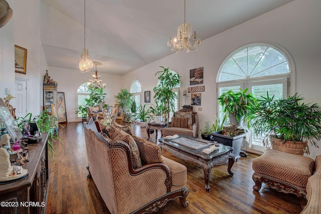 living room with high vaulted ceiling, a chandelier, and hardwood / wood-style floors