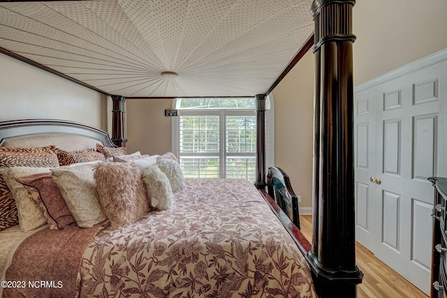 bedroom featuring crown molding and light hardwood / wood-style floors