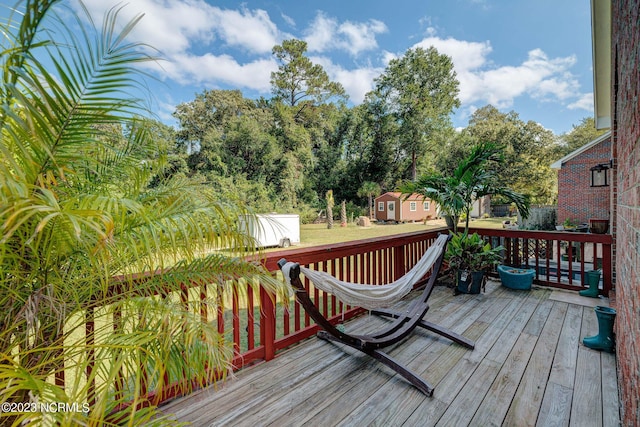 wooden terrace with an outbuilding and a lawn