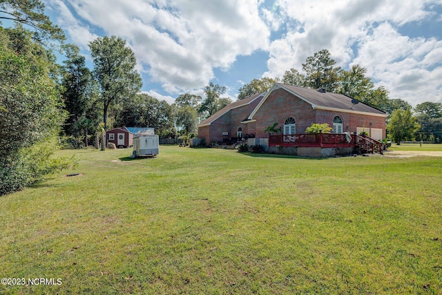 view of yard featuring a deck and a shed