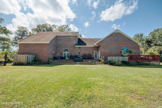 back of house featuring a wooden deck and a yard