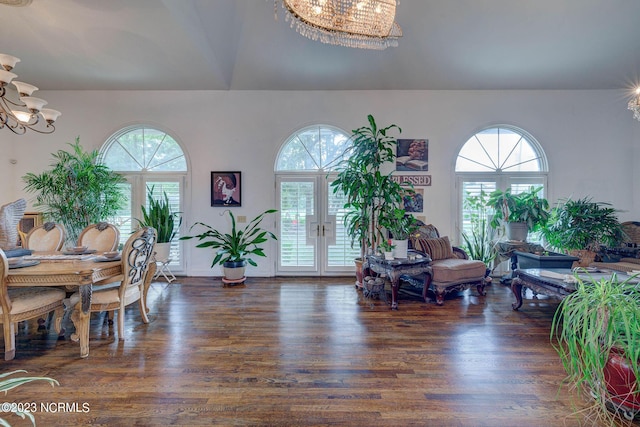 living room with plenty of natural light, dark wood-type flooring, and a chandelier