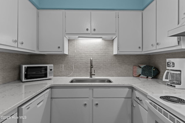 kitchen with white cabinetry, sink, white appliances, and tasteful backsplash