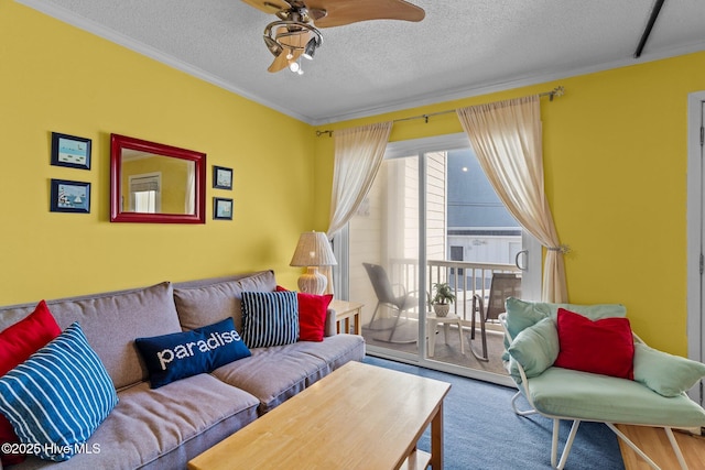 living room featuring ceiling fan, carpet, ornamental molding, and a textured ceiling