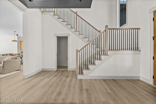 stairs with a high ceiling and wood-type flooring