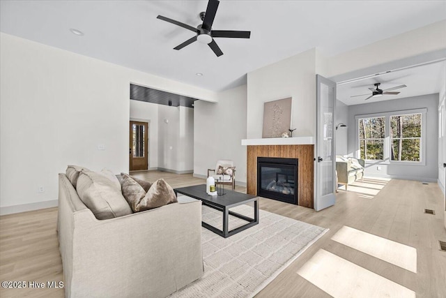 living room featuring ceiling fan and light wood-type flooring