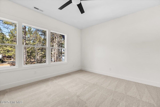 carpeted spare room featuring ceiling fan