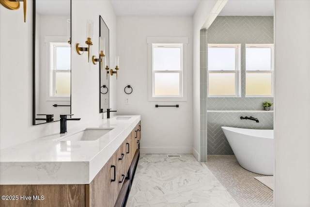 bathroom featuring a tub to relax in, vanity, and tile walls