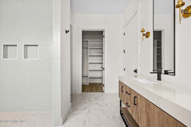 bathroom with vanity and a tile shower