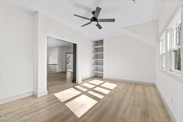 spare room featuring ceiling fan, built in features, and light hardwood / wood-style flooring