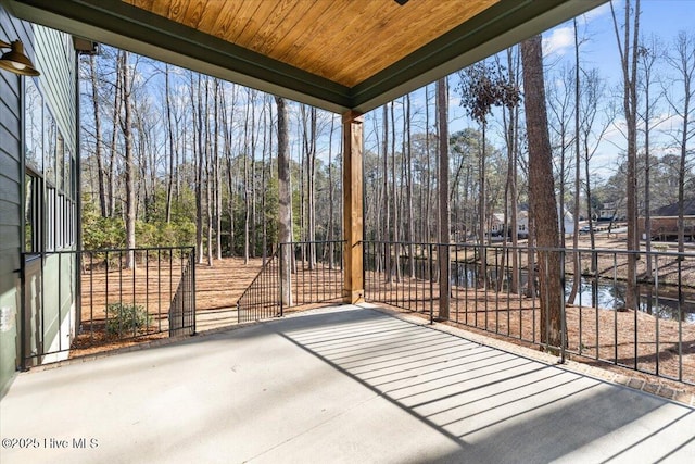 unfurnished sunroom with a water view and wooden ceiling