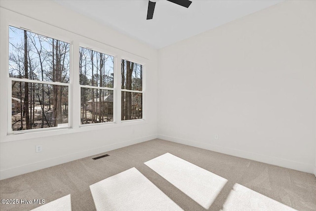 unfurnished room featuring a healthy amount of sunlight, carpet flooring, and ceiling fan