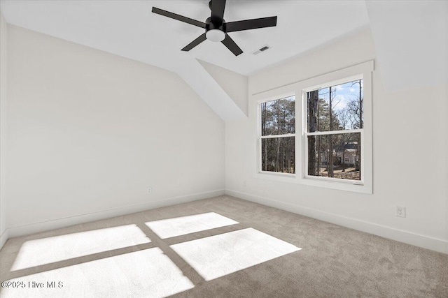 unfurnished room with light carpet, vaulted ceiling, and ceiling fan