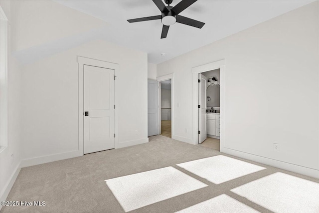 unfurnished bedroom with light carpet, sink, and ensuite bath