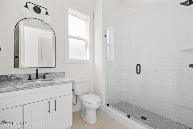 bathroom featuring vanity, toilet, and a shower with door