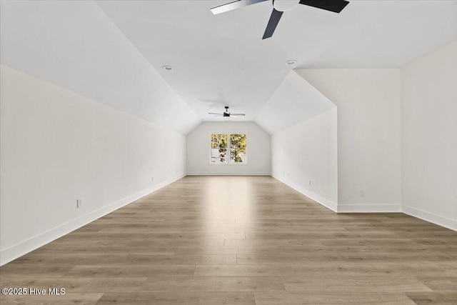 additional living space featuring wood-type flooring, lofted ceiling, and ceiling fan