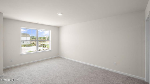 unfurnished room with carpet flooring and baseboards