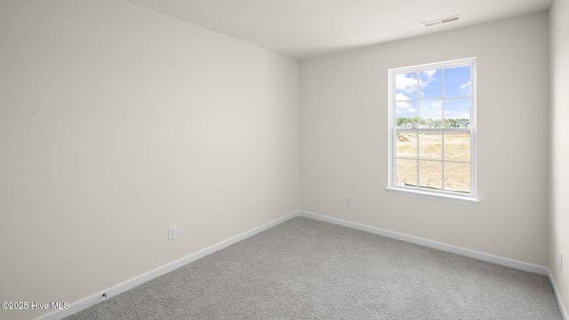 unfurnished room featuring baseboards, visible vents, and carpet flooring