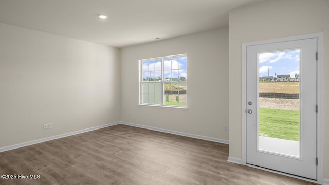 doorway to outside with baseboards and wood finished floors