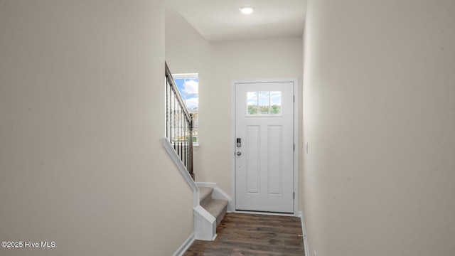 foyer entrance with stairs, wood finished floors, and baseboards