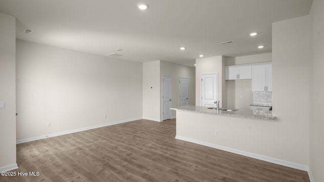 kitchen with tasteful backsplash, baseboards, dark wood-style flooring, white cabinetry, and recessed lighting