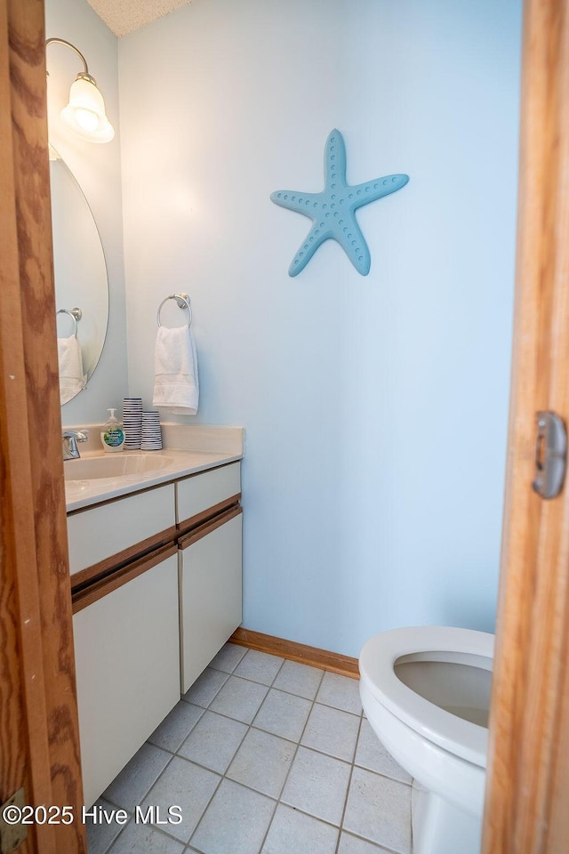 bathroom featuring vanity, tile patterned floors, and toilet