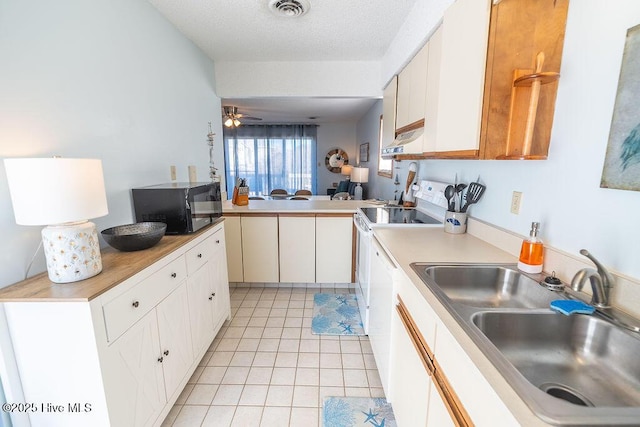 kitchen with light tile patterned flooring, white cabinetry, sink, kitchen peninsula, and a textured ceiling