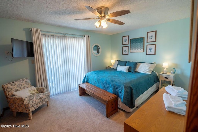 bedroom with ceiling fan, light carpet, and a textured ceiling