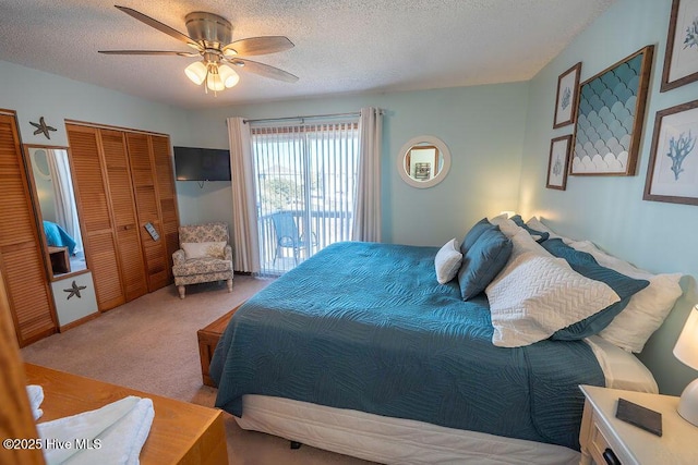 bedroom featuring ceiling fan, light colored carpet, a textured ceiling, and access to exterior