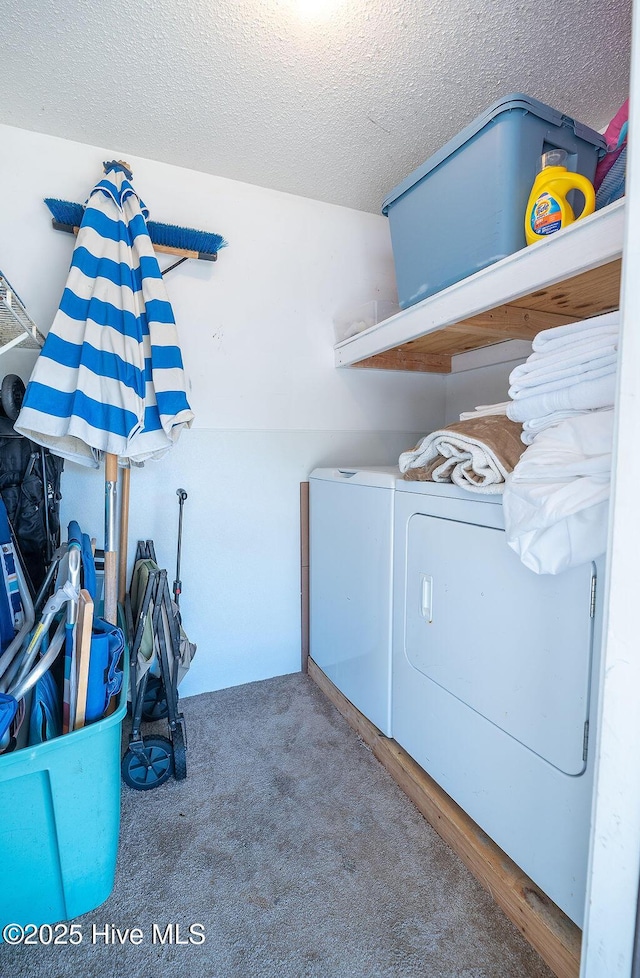 laundry area with carpet floors, washer and dryer, and a textured ceiling