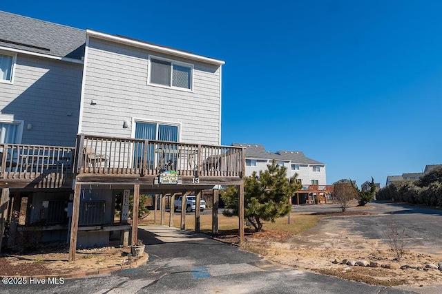 back of property with a carport and a wooden deck