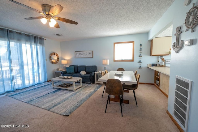 dining room featuring light colored carpet, heating unit, and a textured ceiling