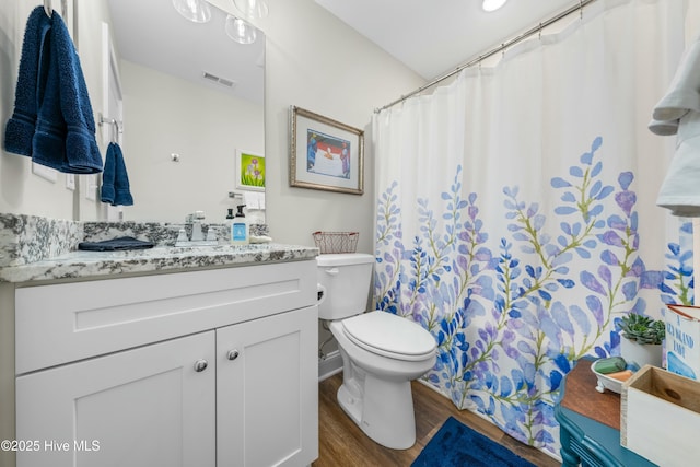 bathroom featuring wood-type flooring, vanity, and toilet