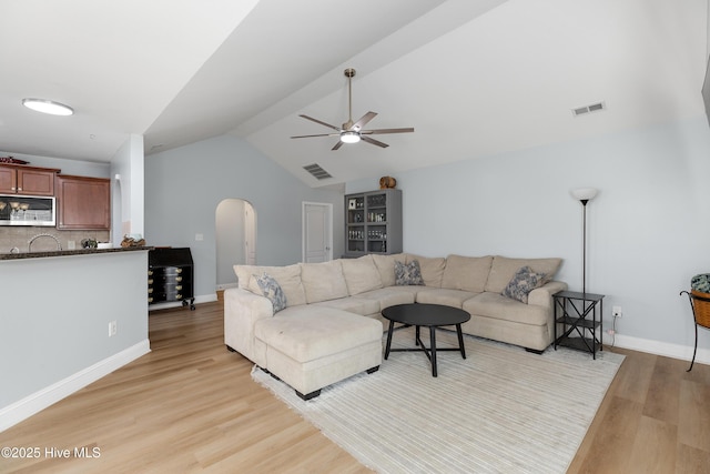 living room featuring ceiling fan, lofted ceiling, and light hardwood / wood-style flooring