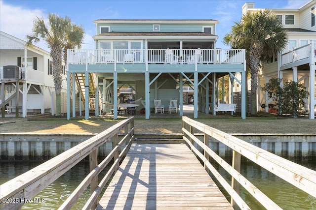 dock area featuring a water view, central AC, and a lawn