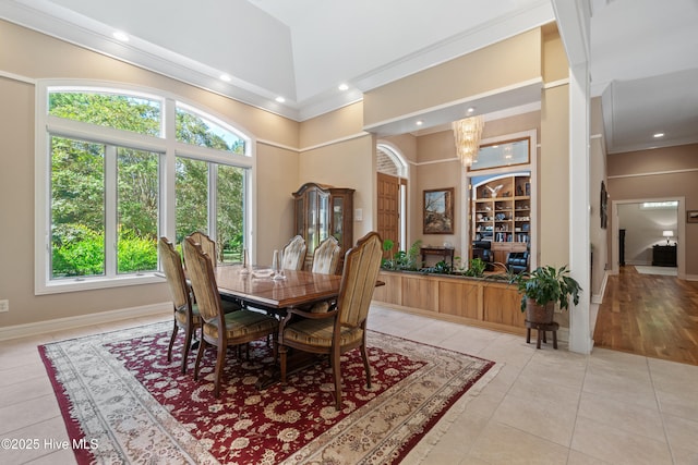 dining room featuring crown molding, a chandelier, light tile patterned floors, and high vaulted ceiling