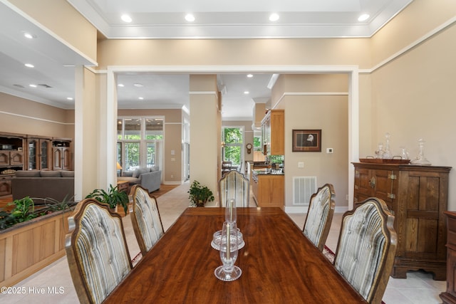 tiled dining space featuring crown molding