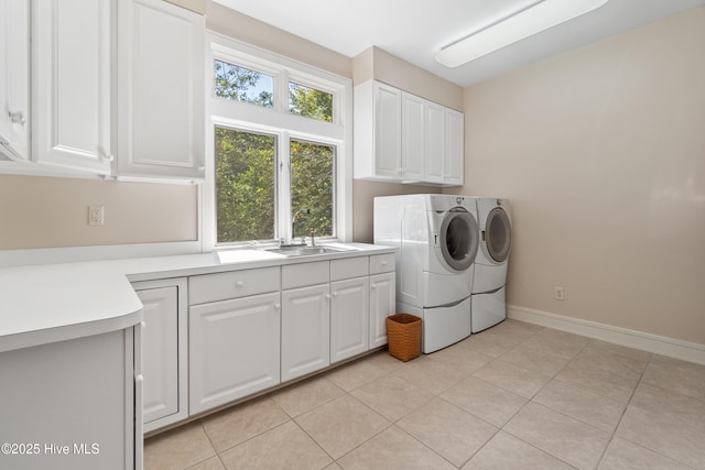 laundry room with cabinets, sink, washing machine and dryer, and light tile patterned floors