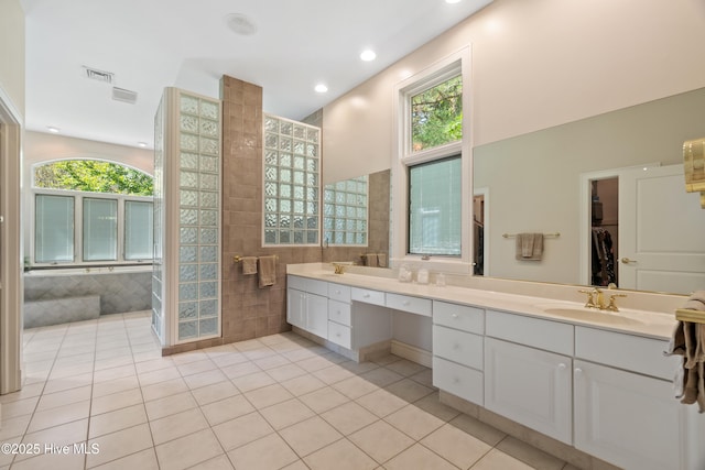 bathroom featuring vanity, a wealth of natural light, tile patterned floors, and tile walls