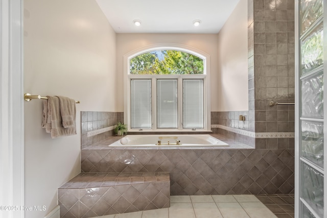 bathroom featuring tile patterned flooring and tiled bath