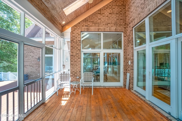 unfurnished sunroom with lofted ceiling with skylight and wooden ceiling