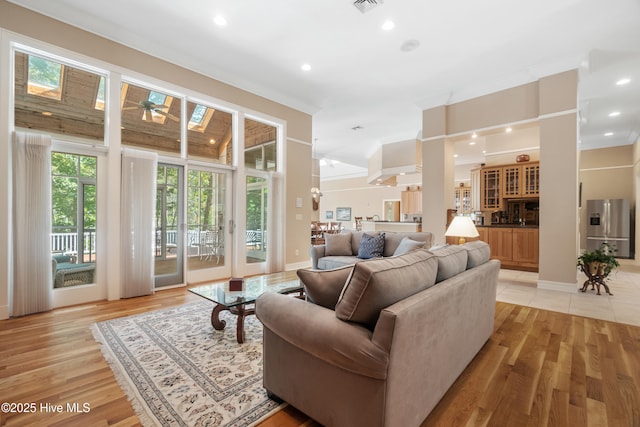 living room with crown molding and light wood-type flooring