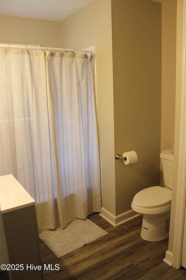 bathroom with wood-type flooring, vanity, and toilet