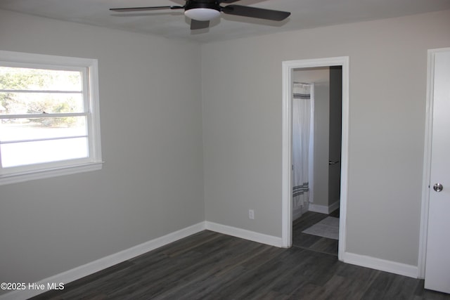 empty room with dark hardwood / wood-style floors and ceiling fan