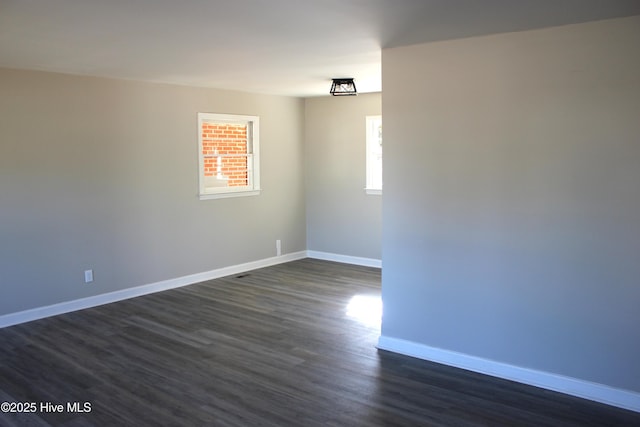 spare room with dark wood-type flooring